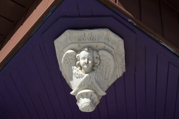 angel face with wings corbel installed in the soffit of a shop © eugen