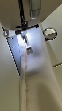 Sewing machine needle threading lace fabric in close-up shot