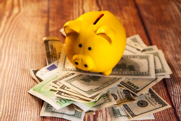 Piggy bank and money on wooden background. Saving concept.