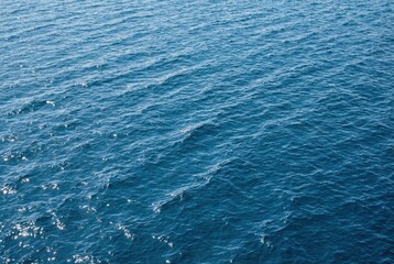 Obraz premium Deep blue ocean water surface with gentle ripples and sunlight reflections