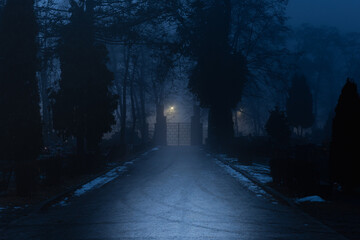 Cmentarz komunalny w mieście Żagań w Polsce. Brama główna w mglisty, zimowy wieczór. © boguslavus