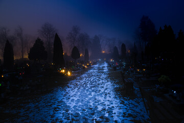 Cmentarz komunalny w mieście Żagań w Polsce. Cmentarna alejka w zimowy, mglisty wieczór.  © boguslavus