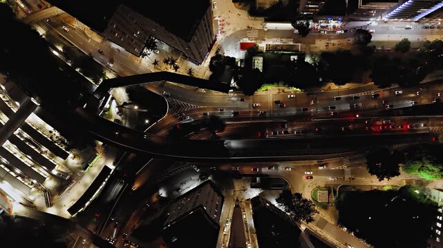 Night aerial overhead tracking view following Avenida 9 de Julho from intersection with Avenida 23 de Maio in Sao Paulo, Brazil. Drone shot revealing Terminal Bandeira and illuminated avenue with traf