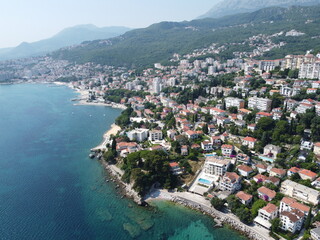 Fototapeta premium Picturesque Coastal Cityscape With Turquoise Water and Mountain Backdrop