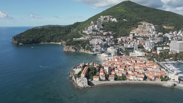 A scenic panoramic view of Budva, a coastal city in southern Crna Gora. Aerial drone video. Flying backwards.