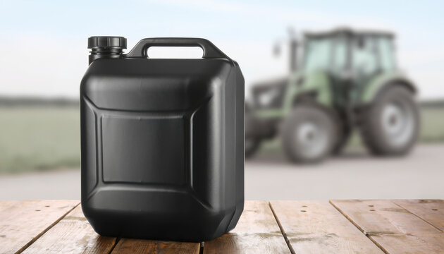 Black jerrycan standing on wooden table with tractor