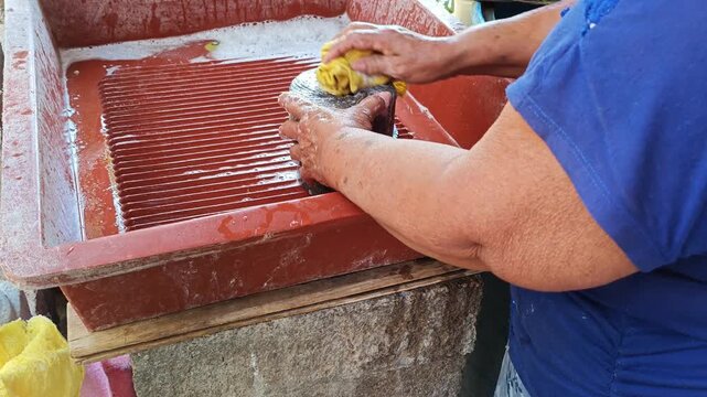 Woman washing traditional grinding stones with soap
