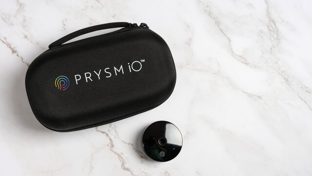 Prysm iO skin carotenoid scanner device and carrying case by Nu Skin on marble background.