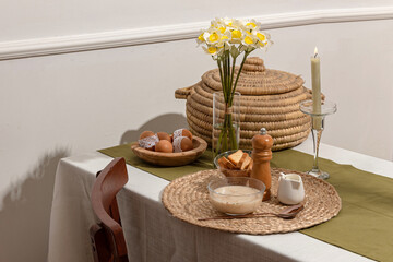 Fototapeta premium Cozy Rustic Breakfast Table with Soup, Bread and Spring Flowers