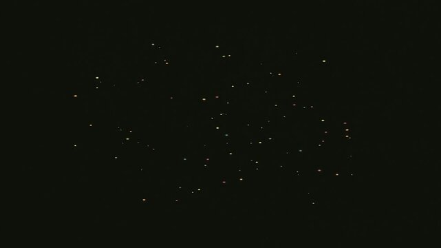 Abstract pattern of small dots and shapes on a dark background.