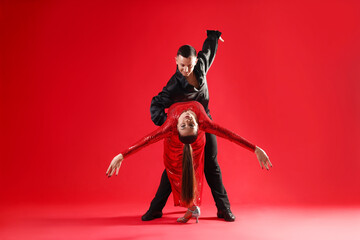 Couple of professional dancers on red background
