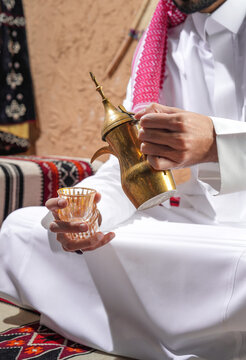 Gulf Arabian young man with traditional welcome hospitality coffee, arabic Coffee pot traditional. Saudi Coffee Dallah, A still life of Saudi traditional coffee pot or Dallah.
