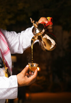 Gulf Arabian young man with traditional welcome hospitality coffee, arabic Coffee pot traditional. Saudi Coffee Dallah, A still life of Saudi traditional coffee pot or Dallah.
