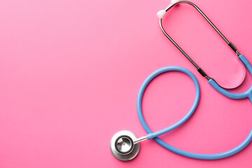 Fototapeta premium One stethoscope on pink background, top view. Space for text