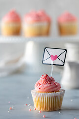 A sweet vanilla cupcake with pink frosting and sprinkles for Valentine's Day.