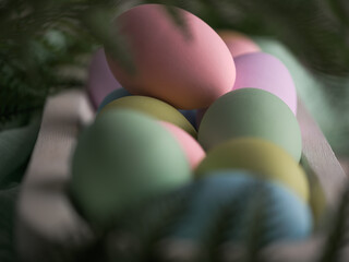 Macro closeup of Spring pastel color holiday Easter eggs in rustic farmhouse white wood bowl surrounded by greenery.
