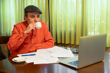 Senior man drinking coffee during remote work session