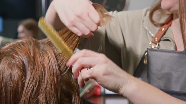 Professional hairdresser trims woman's long hair length with sharp scissors in bright beauty salon. Client watches mirror reflection, relaxed during precise haircut consultation and styling 