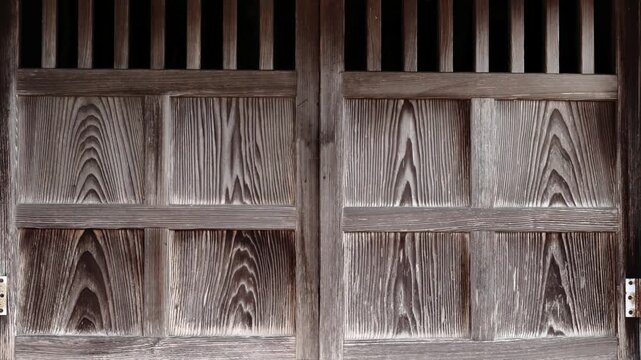 木製の扉が開かれる場面