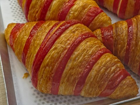 Bicolor Rasberry Croissants with Distinct Red and Golden-brown Buttery Strips.