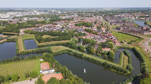 star shaped water filled fortifications manicured green embankments sports grounds red roofed neighborhoods historic town spread into flat countryside geertruidenberg outward netherlands 