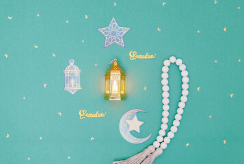 Moroccan lantern, rosary, Ramadan inscription and paper decorative elements.