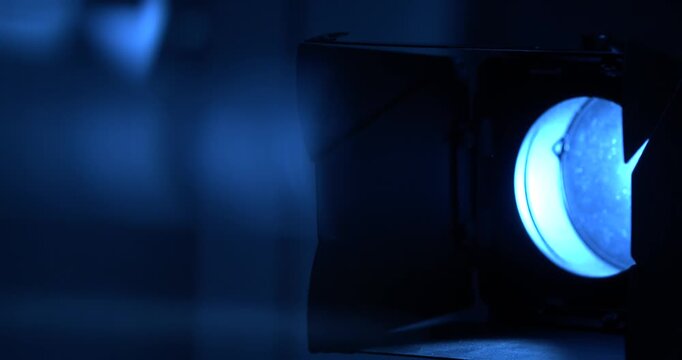 Slow motion, Tight Blue Stage Lamp Creating Vignette Backstage Crew Adjusts Barn Doors Focused Beam Hardware