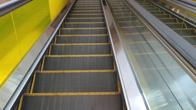 Overhead View of Two Parallel Modern Escalators with Bright Yellow Side Panels.