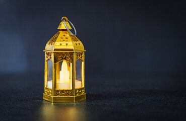Golden glowing decorative mini Moroccan lantern on table.