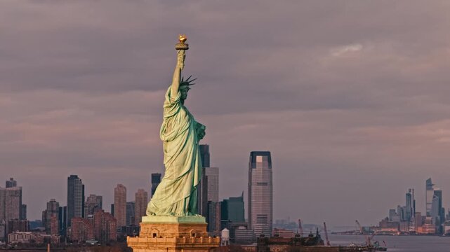 Liberty statue and New York City skyline from aerial view. Aerial urban view with iconic Liberty statue. Drone aerial view of Liberty statue and downtown skyline. Liberty statue rising above NYC.