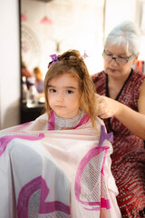 Little girl getting first haircut at hair salon