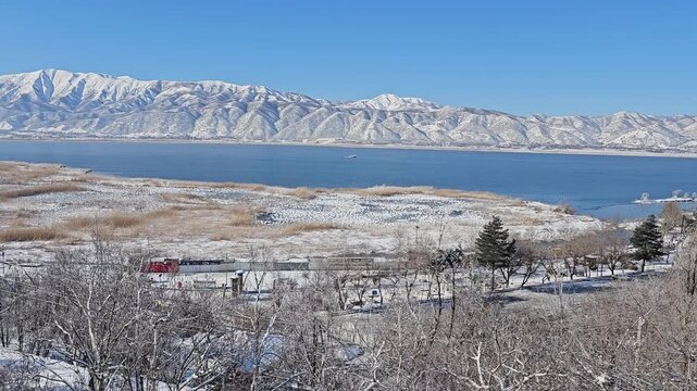 Winter lake surrounded by snowy trees and Zagros mountains under a clear blue sky, creating a peaceful and scenic natural landscape.  
📍Zaribar lake, Marivan