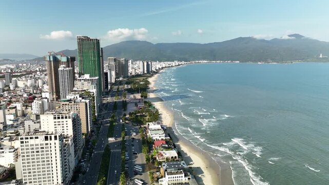 My Khe Beach, Da Nang, Vietnam &ndash; 4K aerial drone footage of tropical coastline, sandy beach, palm-lined coastline, ocean waves, and modern city skyline, costal roads, Son Tra Peninsula
