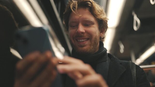 Young man using smartphone commuting on public transport