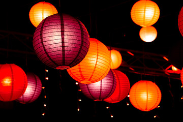 chinese lantern festival Vibrant red, orange, and purple paper lanterns illuminate the dark night, creating a warm, festive atmosphere rich in Asian cultural heritage and celebration. © นิรมล บุญเทพ