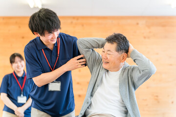 Obraz premium A male physiotherapist providing physical therapy to a senior manA male physiotherapist providing physical therapy to a senior man