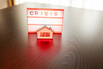 House miniature and light box showing word crisis