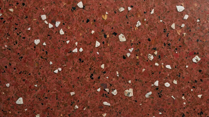 A terrazzo red surface with a polished concrete look, blending marble and granite chips to create a smooth, decorative texture. Ideal for floors, walls, and modern interior finishes. © Hesho