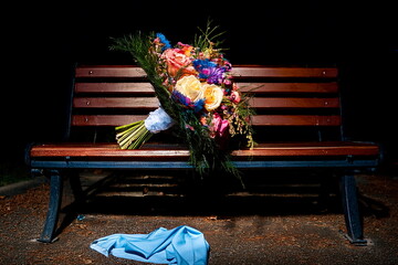 暗めの夕暮れのベンチにおき忘れた花束