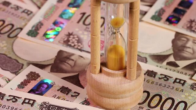 一万円札（新札）と砂時計：残り時間と資産のイメージ