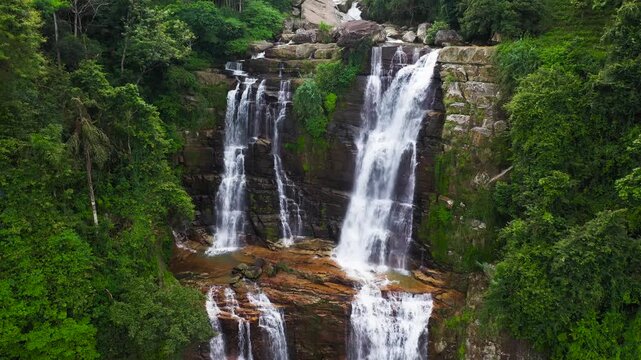 Waterfall among tropical jungle with green plants and trees. Lower Ramboda Falls. Sri Lanka.