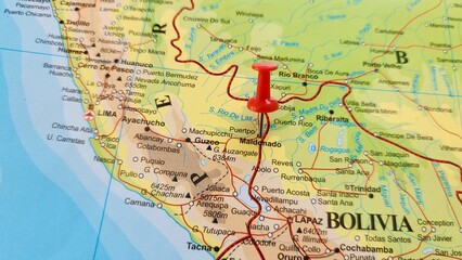Obraz premium View of Puerto Maldonado, Capital city of Madre de Dios, Peru, on a geographical map of America, marked with red push pin