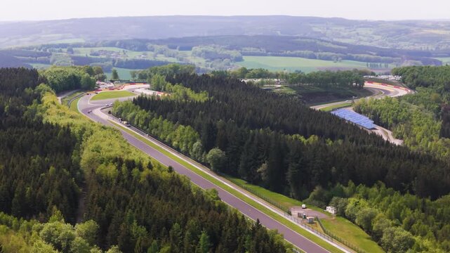 belgium f1 formula one circuit runs through ardennes forest 1 cars straight eau rouge dense trees rolling countryside toward spa francorchamps section 
