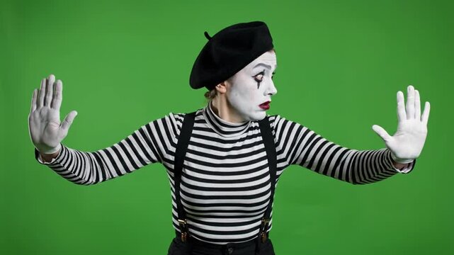 Female mime making stop gesture on green screen