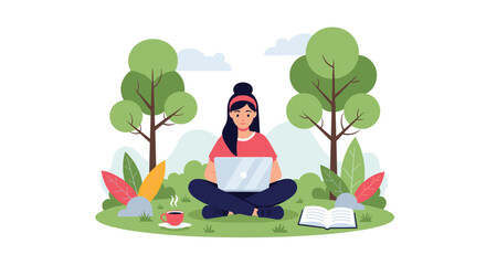 Young woman sitting cross legged in a park working on her laptop with a cup of coffee and an open book nearby on the green grass.