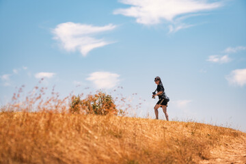 Low angle view of woman walking in the field on hilltop under the blue sky, Mount Osmond, Adelaide, South Australia, Australia