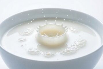 Captivating crown shaped milk splash with liquid drops in a pristine white bowl