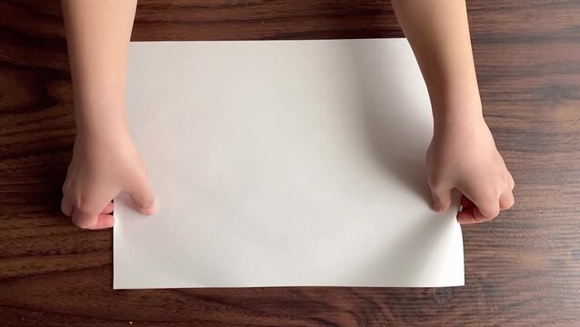 Child Picking Up A4 Paper from Table in Slow Motion