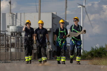 Engineer coordinating operations at an energy facility with wind turbines, highlighting teamwork, technical planning, safety and the development of clean and sustainable renewable power solutions.