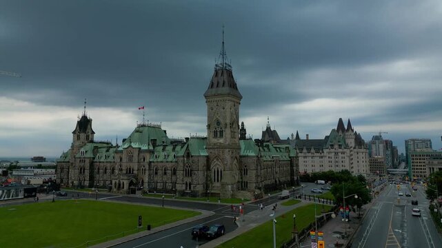 East Block Federal Government building at 111 Wellington Street was viewed amidst the heavy clouds of a grim wet summer day with some traffic in the immediate area remaining notably light lush grass